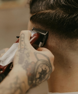 Barbeiro realizando corte de cabelo na máquina